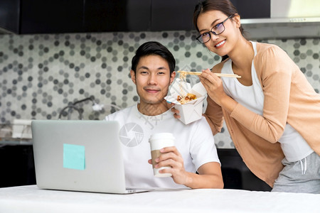 亚洲夫妇在家工作厨房送货取走食物而城市则被封锁远离科罗纳coronaviruscovid19的流行病新正常生活方式从家里工作图片