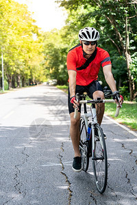 穿着运动服骑自行车运动员在农村公路上骑行图片