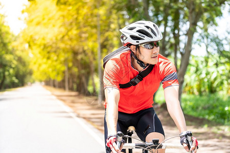 穿着运动服骑自行车运动员在农村公路上骑行欣赏风景图片