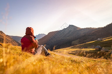 穿运动服的妇女正在享受山区的日落坐在地上享受风景图片