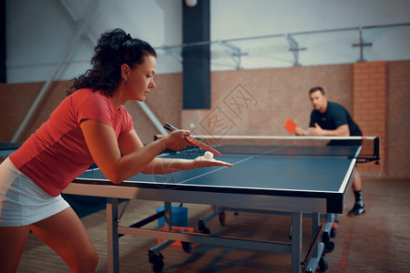 网球男女乒乓运动员在室内打桌球的男女员打的体育比赛积极的健康生活方式打网球的男女乒乓员在室内打桌球的男女员图片
