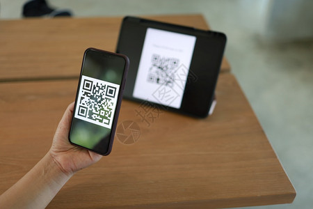 Qr代码支付E钱包妇女扫描QR在线无现金购物技术概念图片