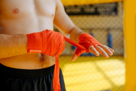 男MMA战斗机在健身房将绷带包在手上戴戒指的肌肉人准备战斗武术训练MMA战斗机在健身房将绷带包在手上图片