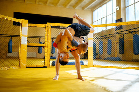 两名男MMA战士在健身房的笼子里战斗两名男MMA战士在笼子里斗两名男MMA战士在笼子里斗图片