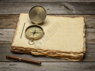 旧铜指南针与生锈的风化木材相对应图片
