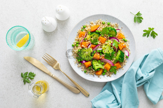 蔬菜quinoa和花椰菜热沙拉上面有烤胡桃南瓜或绿豆和新鲜红洋葱图片