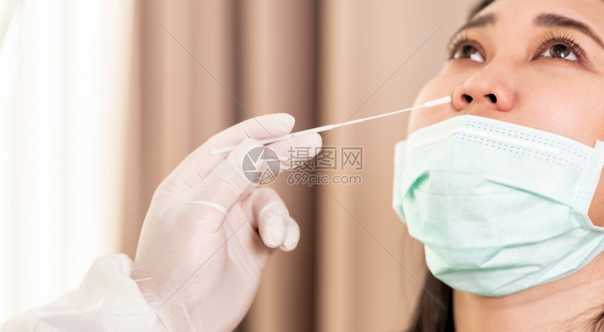 PPE防护服测试新冠共19岁的医务人员在全方位通过鼻孔擦拭向亚裔妇女关闭全景新冠19检测保健概念图片