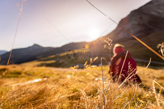 穿运动服的妇女正在享受山区的日落坐在地上享受风景图片