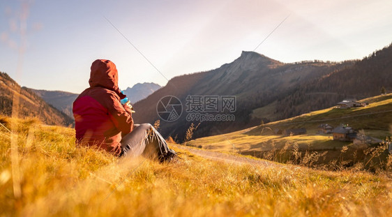 穿运动服的妇女正在享受山区的日落坐在地上享受风景图片