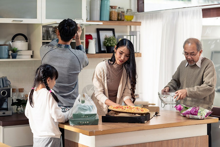 快乐的亚洲多代家庭爸妈女儿孩和祖父在饭前搭餐桌亚洲幸福的家庭一起做务图片
