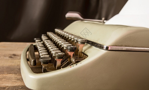 古老的经典金银打字机将空白纸插入木制桌板缝合上图片