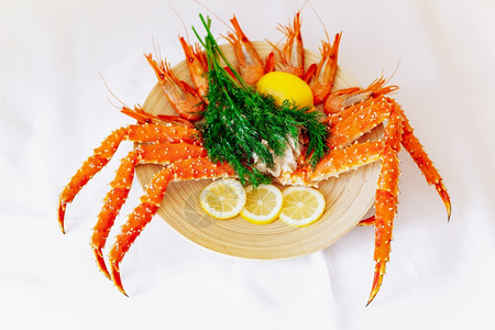 红大螃蟹和虾在盘子上加柠檬和白色背景图片