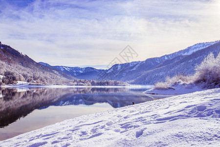 古时冬季风景反射湖雪树和山丘图片