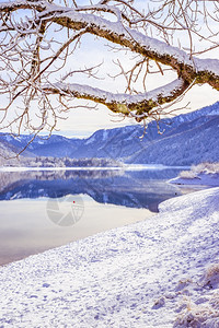 古时冬季风景反射湖雪树和山丘图片