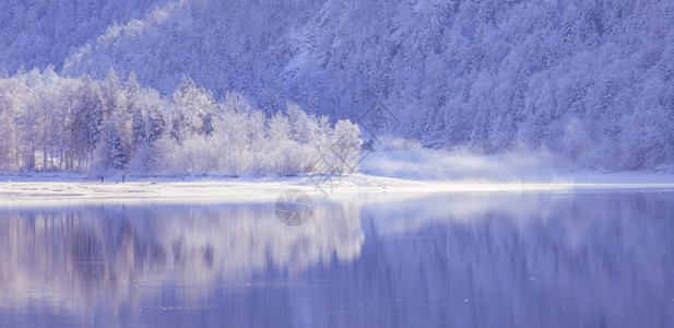 古时冬季风景反射湖雪树和山丘图片