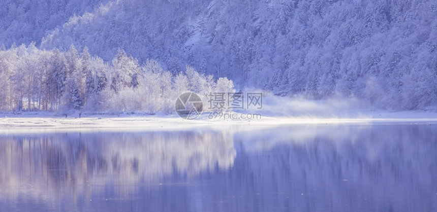 古时冬季风景反射湖雪树和山丘图片