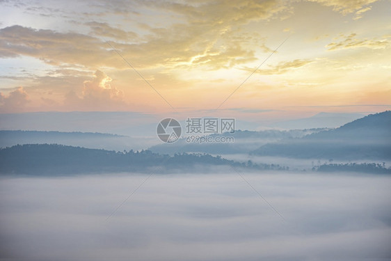 清晨美丽的日出烟雾覆盖乡村冬季的山地背景图片