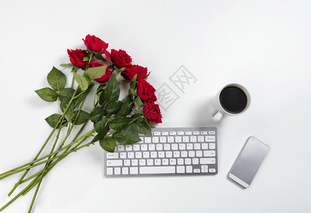 工作桌面上可爱的红玫瑰用于情人节等浪漫概念图片