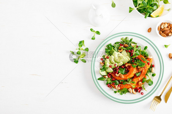 新鲜蔬菜沙拉配有羊肉生菜烤胡桃南瓜或鳄梨石榴腰果和杏仁健康素食品概念图片