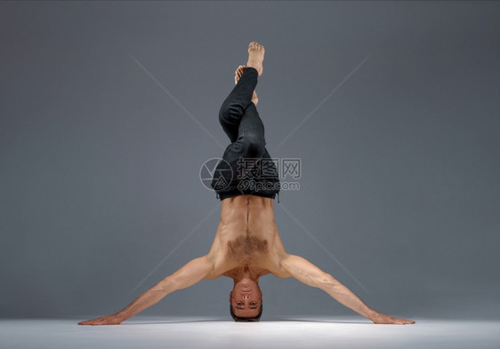 雄瑜伽站在头和手冥想灰色背景强壮的人在做瑜伽运动麻高度集中健康的生活方式图片