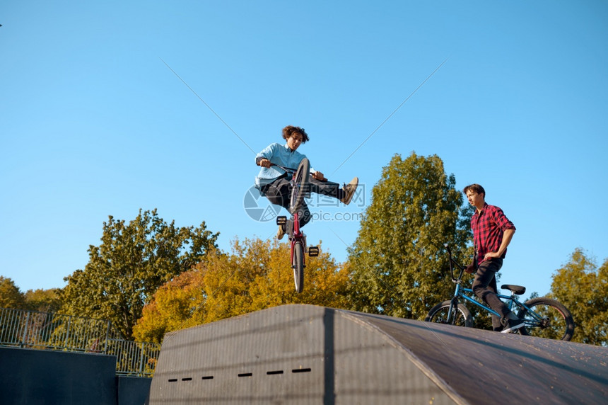 2个bmx骑自行车者在斜坡上跳跃滑板场上训练极端自行车运动危险循环街头骑在夏季公园自行车Bmx骑自行车者在斜坡上跳跃滑板场上训练图片