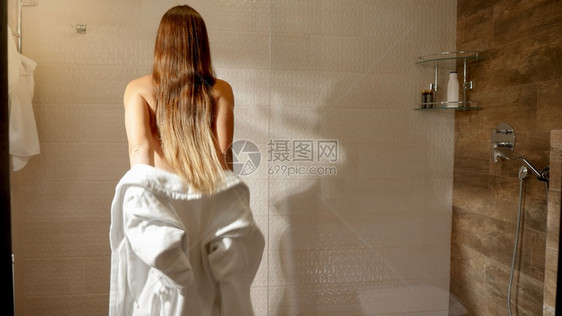 美丽的感女人脱下浴袍在洗澡时散步图片