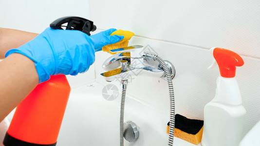 使用化学清洁剂喷雾和海绵在浴室清洗金属水龙头使用化学清洁剂喷雾和海绵在浴室清洗金属水龙头图片