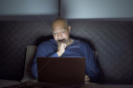 非裔美国人在社交媒体互联网上使用笔记本电脑在家中卧室的床上使用图片