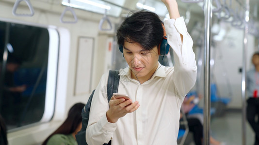 商人在公共火车上使用移动电话图片