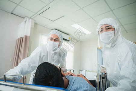 全套防护服和外科口罩的专业医生正在检查院控制区的感染病人图片