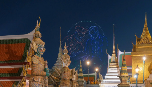露天台泰国王在曼谷翡翠佛寺金塔的巨型守护神雕像上WatPhraKaew和大宫殿城市泰国佛寺晚上图片