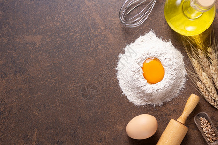 餐桌上自制面包烘的食品粉和鸡蛋作为配方的食谱顶视图放在具有复制空间的石头背景纹理上平板概念图片
