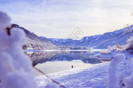 古时冬季风景反射湖雪树和山丘图片