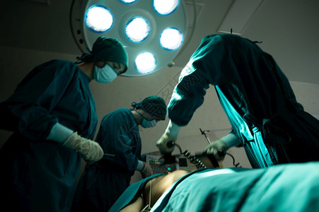 手术室专业外科队紧急外科手术专业智能外科医生站在病人身边救他的同时进行手术背景图片