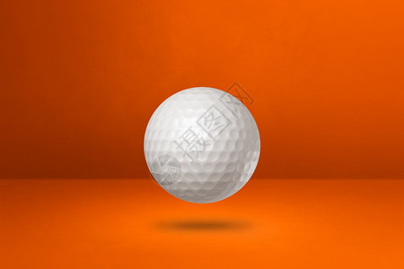 白高尔夫球以橙色工作室背景隔离3D插图图片