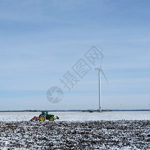 冬季在蓝天下flevoland的dutch产卵地下用雪和拖拉机铺着雪地和拖拉机图片