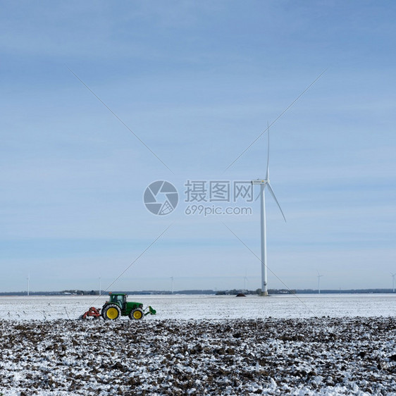 冬季在蓝天下flevoland的dutch产卵地下用雪和拖拉机铺着雪地和拖拉机图片