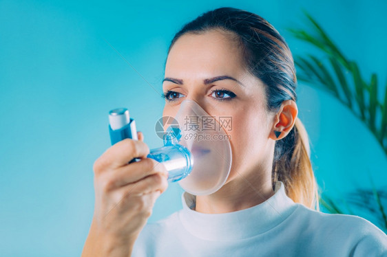 妇女使用带有扩展管的Asthma吸入器妇女使用吸入器进行Asthma图片