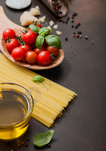 木碗里有意大利面和西红柿有油干酪深棕色底含盐图片