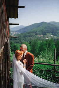 在山上嫁妻新郎和娘生息的房屋旁拥抱新郎娘在郎结婚新郎旁拥抱后美丽的景图片