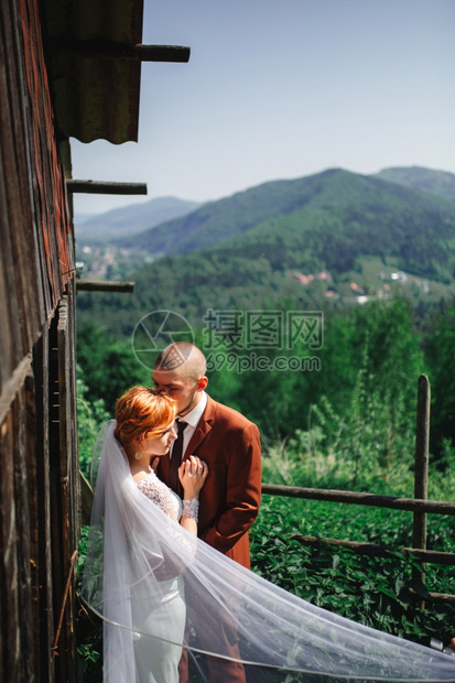 在山上嫁妻新郎和娘生息的房屋旁拥抱新郎娘在郎结婚新郎旁拥抱后美丽的景图片