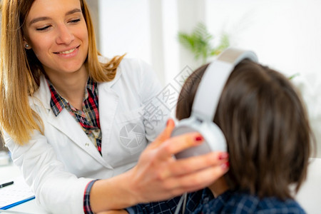 儿童听力测试男孩戴耳机有听力测试儿童与小男孩一起工作的听力专家图片