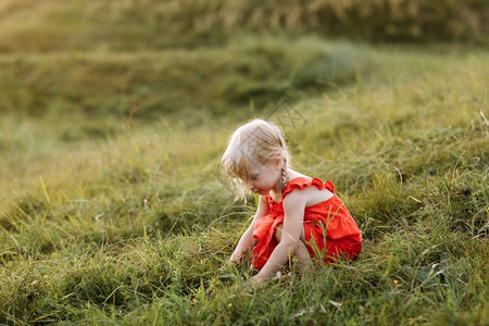 一个穿着红衣服的漂亮女孩肖像暑假时在自然界玩耍日落时在公园玩耍近距离接家庭节日和时间在一起的概念暑假时穿红衣服的漂亮女孩肖像图片