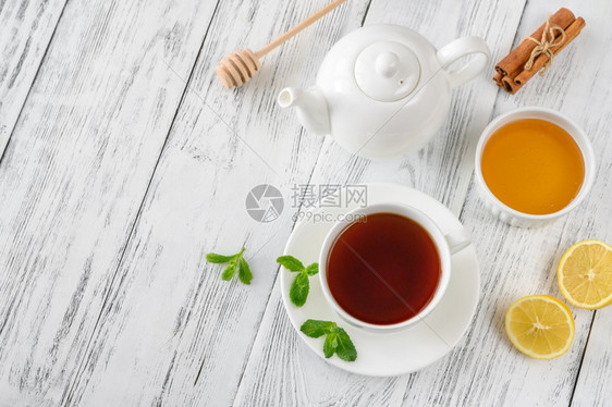 含蜂蜜柠檬和木本底香料的黑茶杯图片