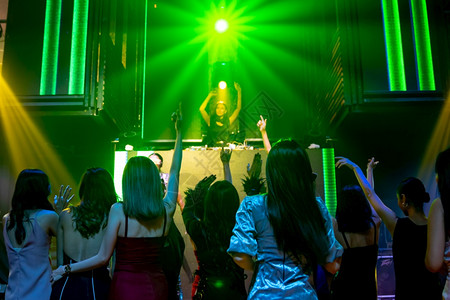 一群人在迪斯科夜俱乐部跳舞音从DJ在舞台上播放新年晚宴和夜生活概念一群人在迪斯科夜俱乐部跳舞音从DJ在舞台上播放图片