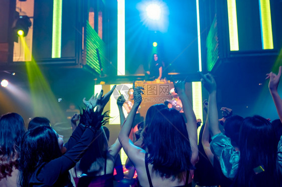 一群人在迪斯科夜俱乐部跳舞音从DJ在舞台上播放新年晚宴和夜生活概念一群人在迪斯科夜俱乐部跳舞音从DJ在舞台上播放图片