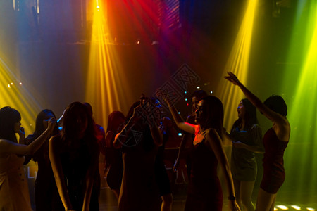在迪斯科夜俱乐部跳舞的人休光片到DJ在舞台上的音乐新年晚会和夜生活概念在迪斯科夜俱乐部跳舞的人休光片到DJ在舞台上的音乐图片