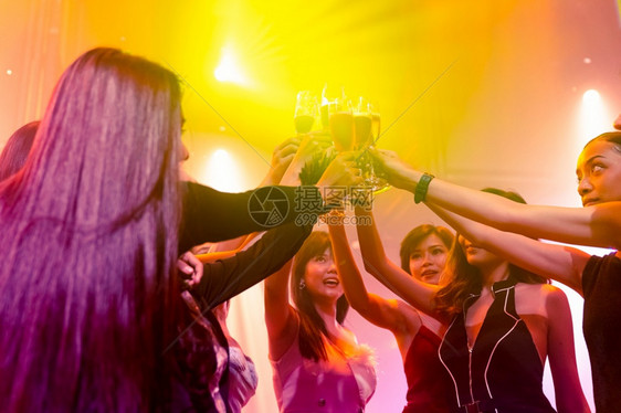 庆祝聚会喝酒和跳舞的年轻人一群朋友在夜里迪斯科俱乐部玩的同时为饮料烤面包友谊和夜生活概念年轻人庆祝聚会喝酒和跳舞图片
