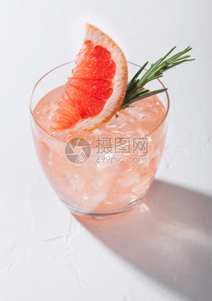 一杯清新夏季红葡萄园鸡尾酒配有冰块水果片和玫瑰以白色背景和深影为图片