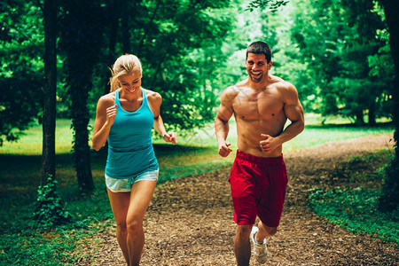 快乐的年轻夫妇在森林中慢跑图片